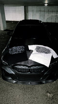 Black and white Built Behind the Chair graphic T-shirts displayed together on a car hood