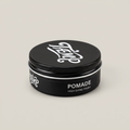 Black pomade tin on a light studio background